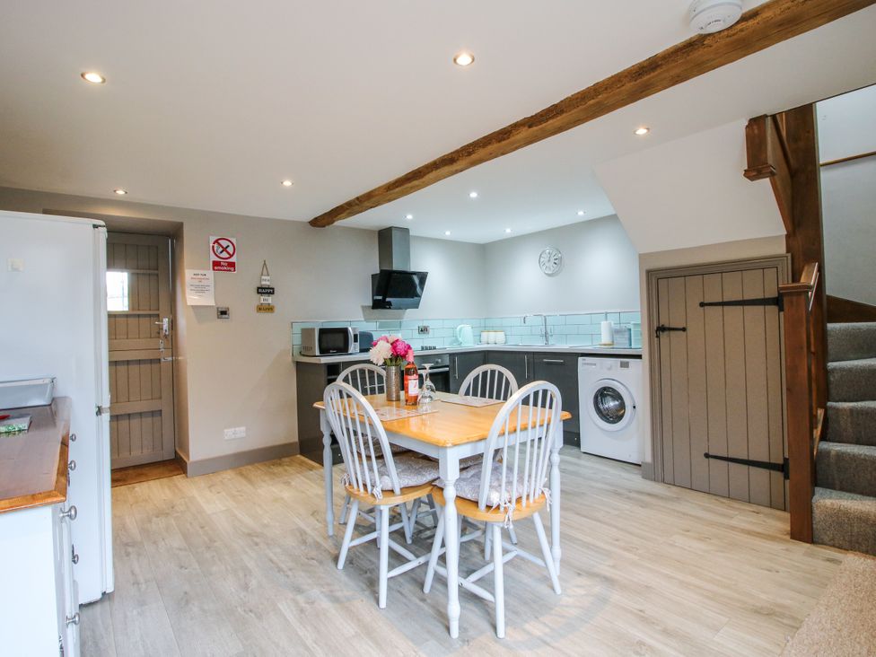 A kitchen with a dining table and chairs at The Hay Loft in Craven Arms