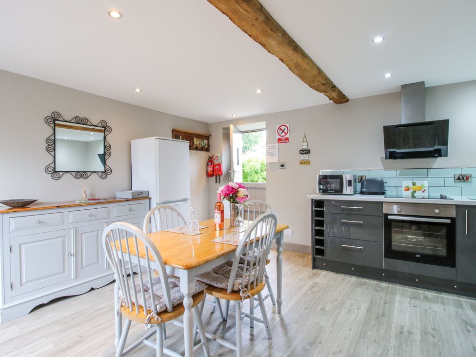 A kitchen with dining table and appliances at The Hay Loft in Craven Arms