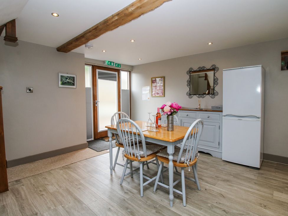 A kitchen with a dining table and chairs at The Hay Loft in Craven Arms