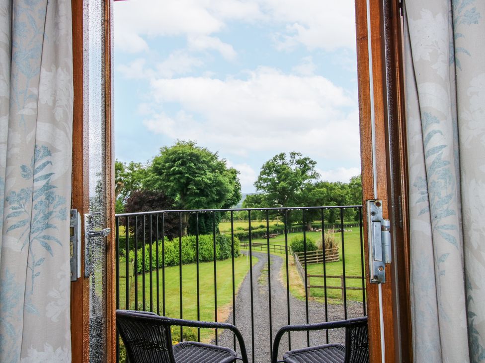 A view from a balcony with chairs and a pathway at The Hay Loft in Craven Arms