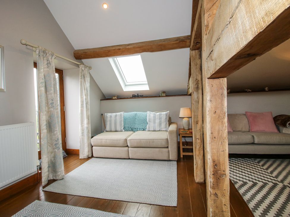 A living room with sofas and a lamp at The Hay Loft in Craven Arms