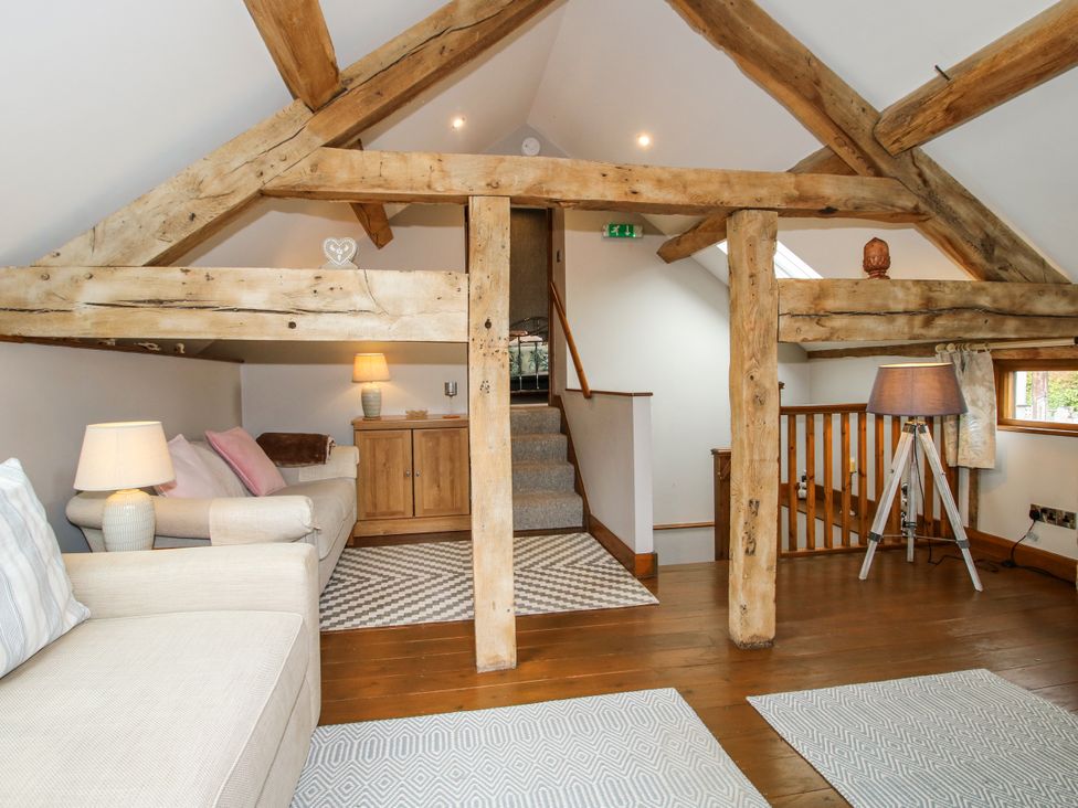 A snug area with sofa and lamp at The Hay Loft in Craven Arms