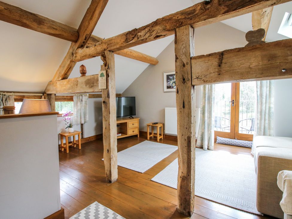 A living room with a sofa and television at The Hay Loft in Craven Arms
