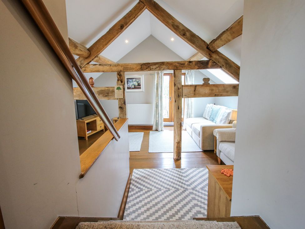 A living room with a sofa and television at The Hay Loft in Craven Arms