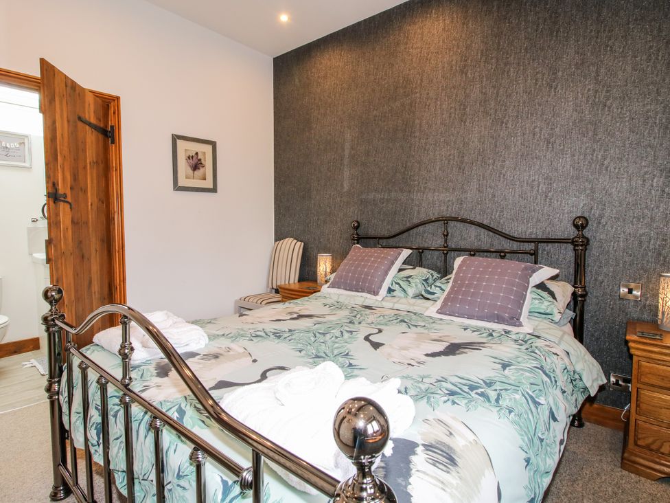 A bedroom with a bed and ensuite bathroom at The Hay Loft in Craven Arms
