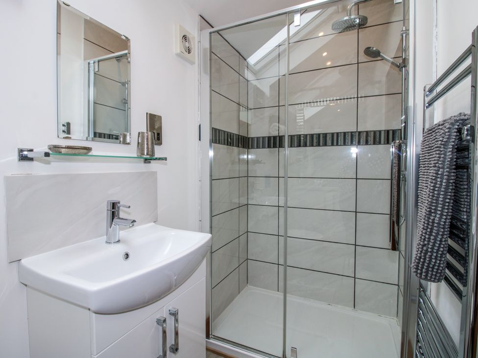 A bathroom with sink, mirror, and shower at The Hay Loft in Craven Arms