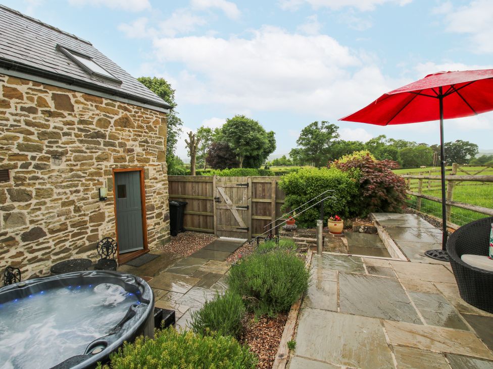 An outdoor area with a jacuzzi and patio at The Hay Loft in Craven Arms