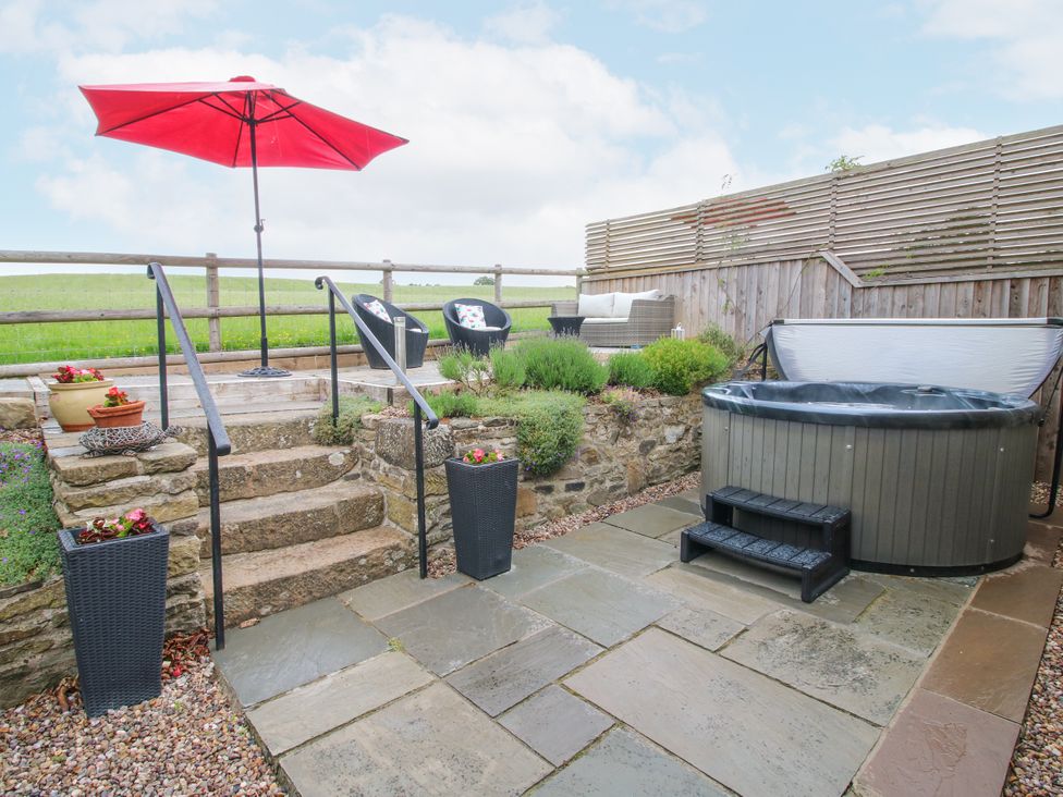 A garden with a hot tub and steps at The Hay Loft in Craven Arms