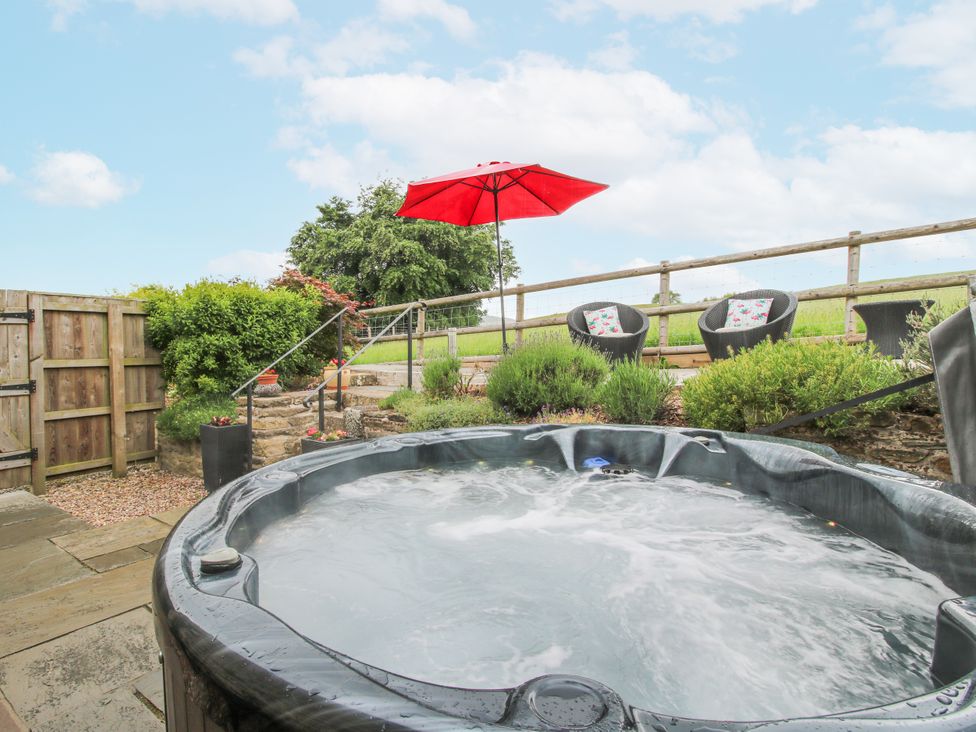 A garden with a hot tub and outdoor seating at The Hay Loft in Craven Arms