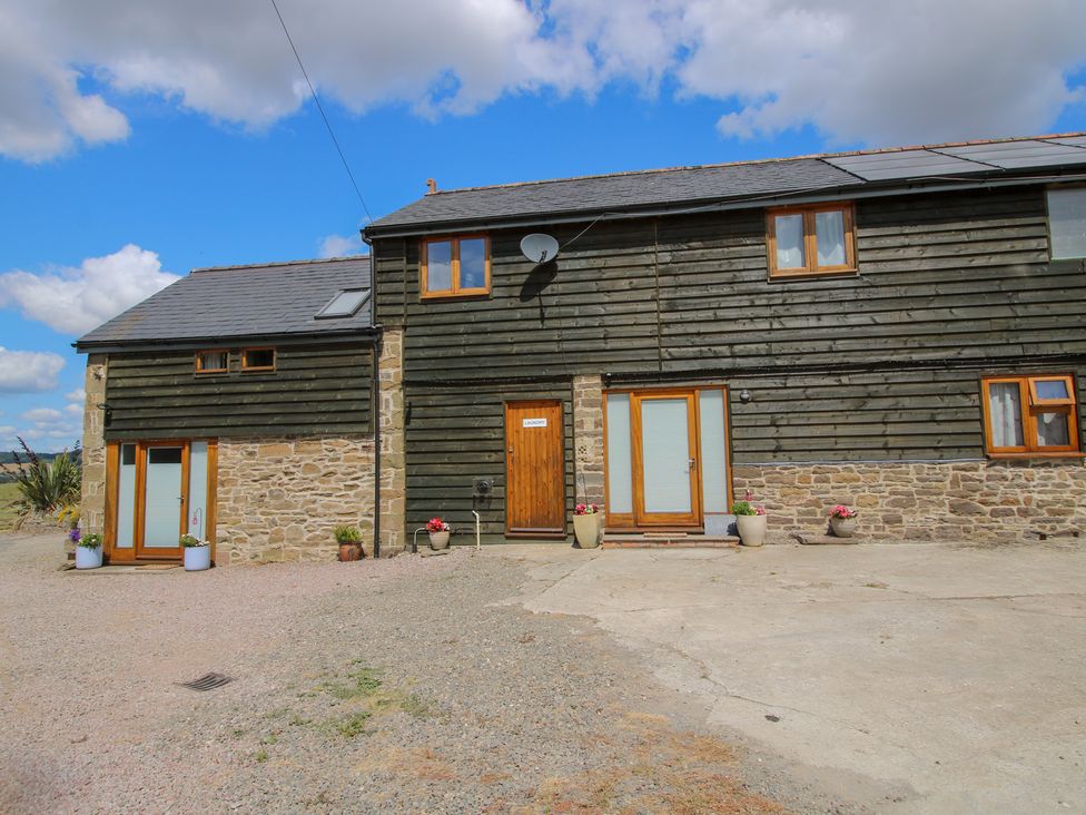 A house with flower pots and a satellite dish at The Hay Loft in Craven Arms