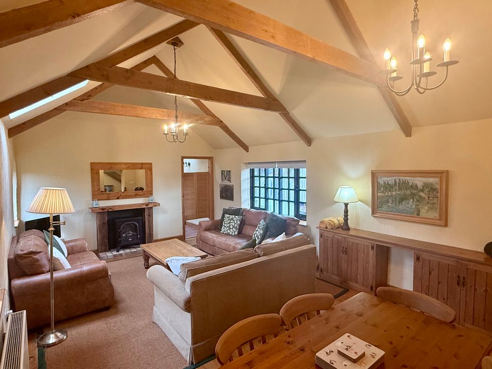 A living room with a sofa, lamp, and fireplace at Meadow Cottage in Golant, near Fowey