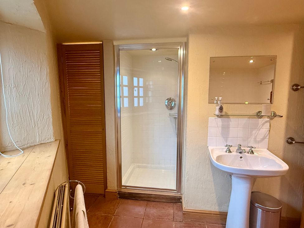 A bathroom with a shower and wash basin at Meadow Cottage in Golant, near Fowey