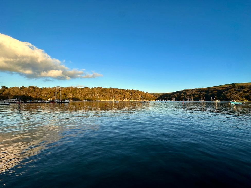 A view of the water with boats and trees in the background at Meadow Cottage in Golant, near Fowey