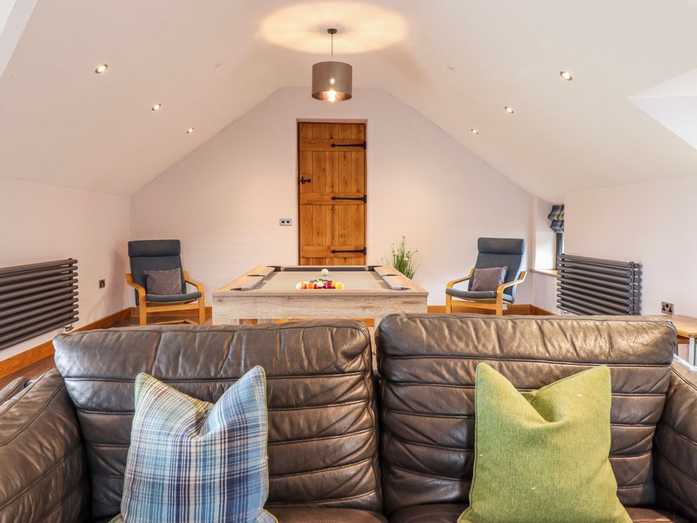 A games room with a pool table and seating at Granar Llangwm near Bala