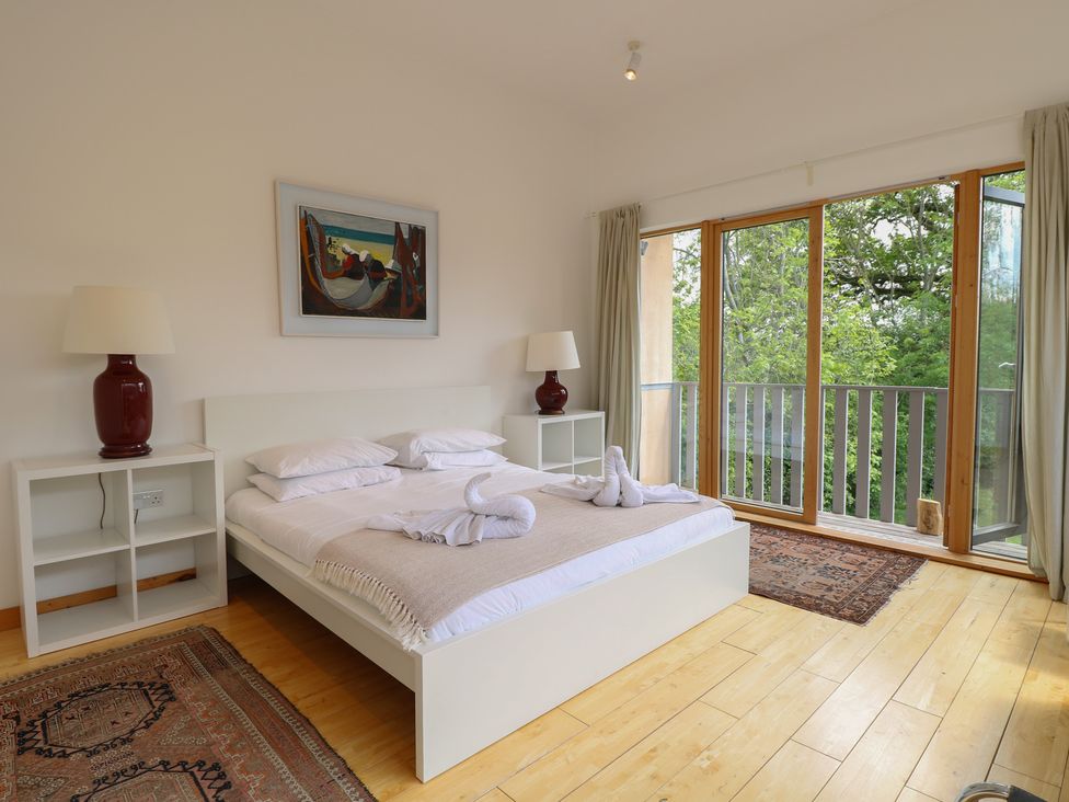 A bedroom with a bed and large windows at Frater House in Denton near Harleston
