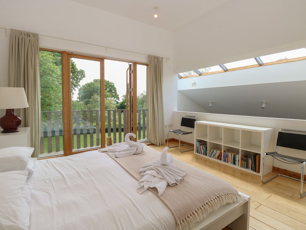 A bedroom with a bed and a bookshelf at Frater House in Denton near Harleston