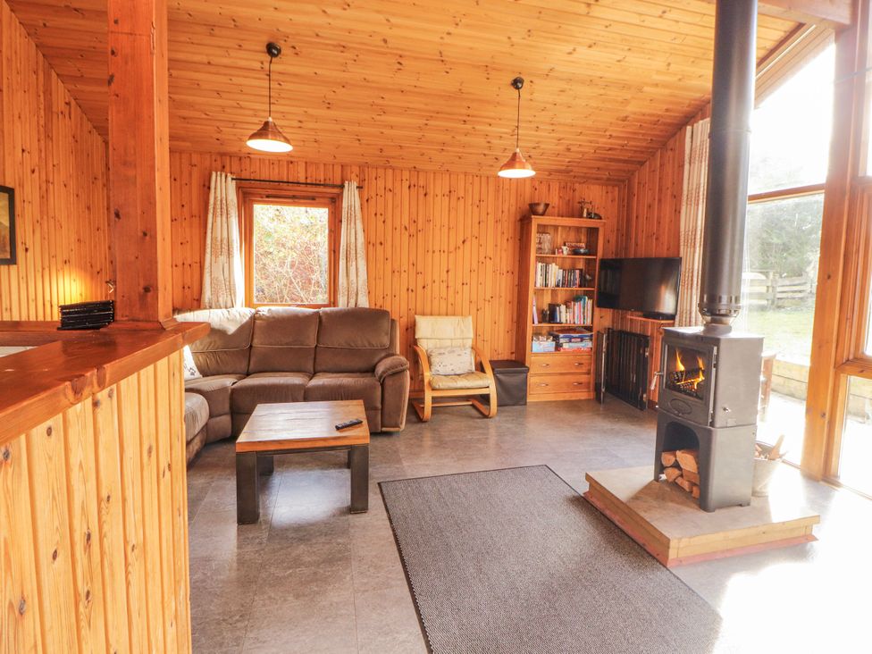 A living room with a sofa and wood stove at 26 Dukes Meadow in Greystoke near Penrith