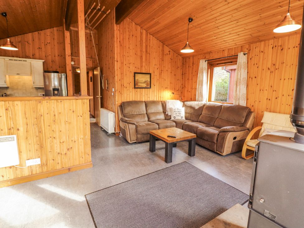 A living room with a sofa, coffee table, and stove at 26 Dukes Meadow, Greystoke near Penrith