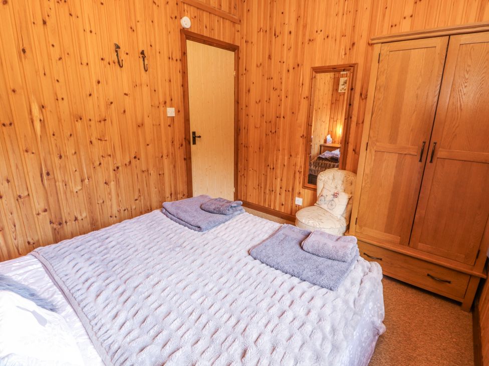 A bedroom with a bed and wardrobe at 26 Dukes Meadow in Greystoke near Penrith