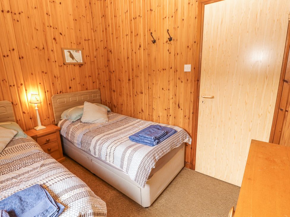 A bedroom with two single beds and a nightstand at 26 Dukes Meadow Greystoke near Penrith