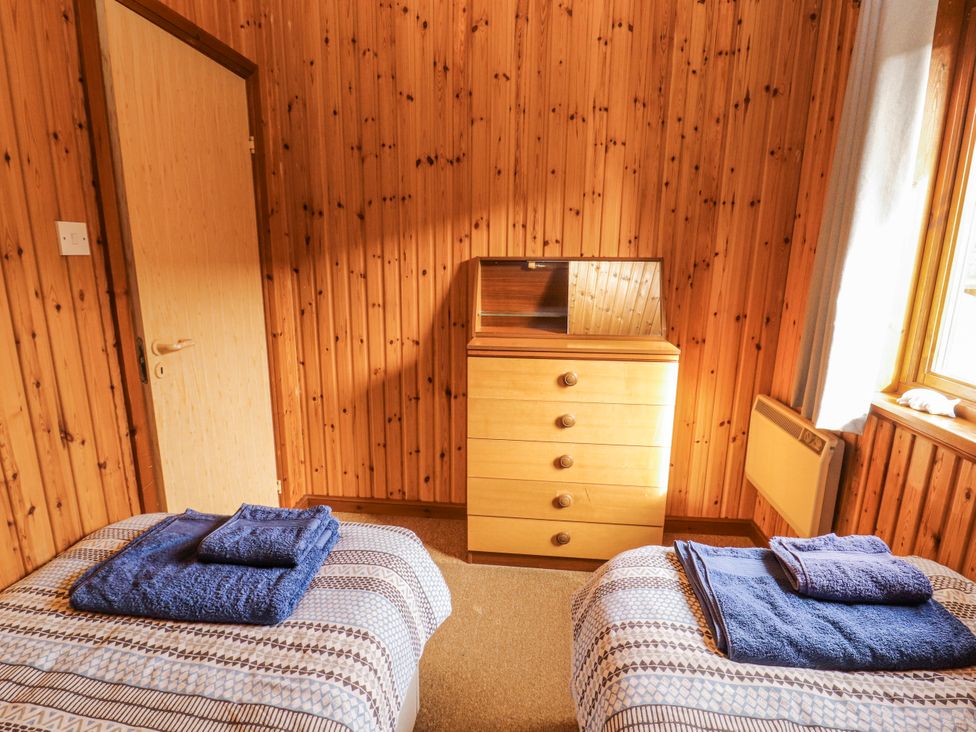 A bedroom with two beds and a dresser at 26 Dukes Meadow in Greystoke near Penrith