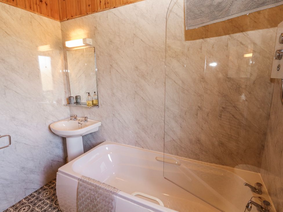 A bathroom with a bathtub and sink at 26 Dukes Meadow Greystoke near Penrith