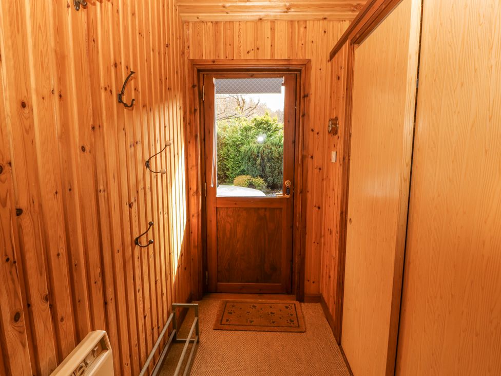 A hallway with coat hooks and a door leading outside at 26 Dukes Meadow Greystoke near Penrith