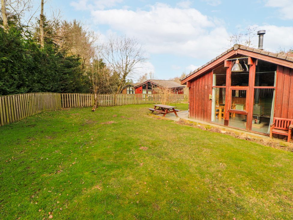 A garden with grass, a table and chairs at 26 Dukes Meadow, Greystoke near Penrith