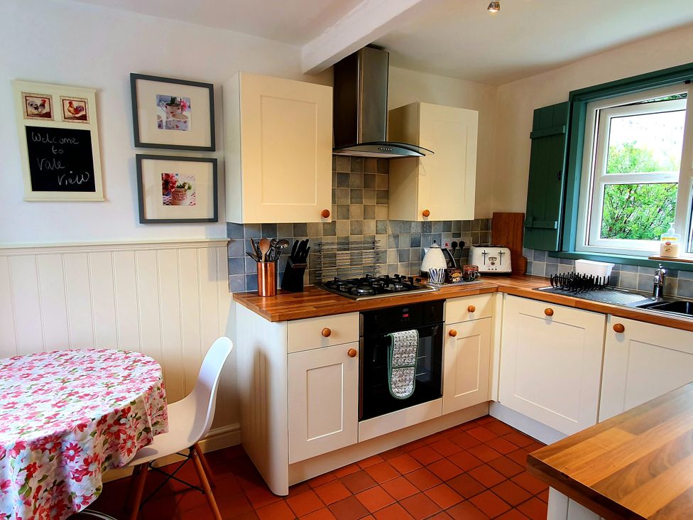 A kitchen with a gas stove and sink at The Coach House in Prestatyn