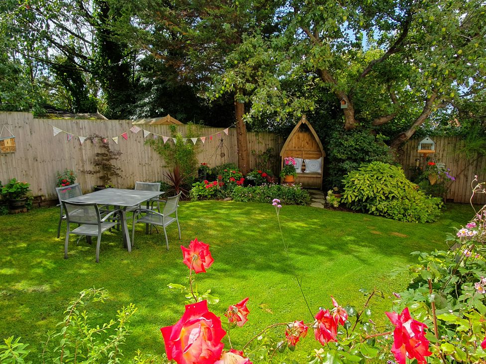 A garden with a table and chairs at The Coach House in Prestatyn