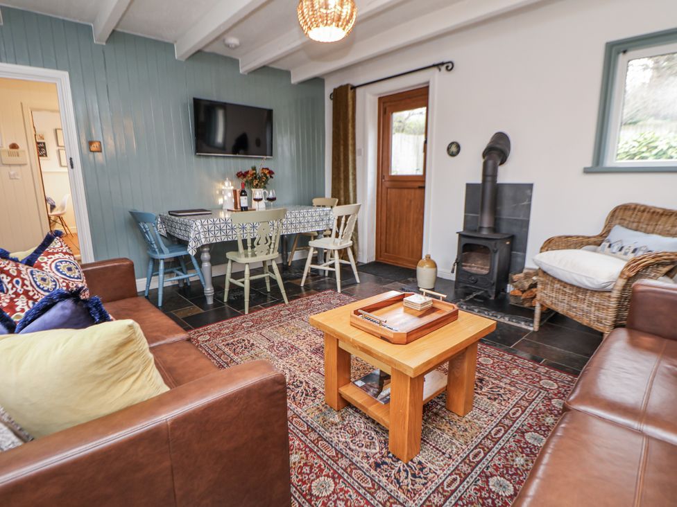 A living room with a coffee table and television at The Coach House in Prestatyn