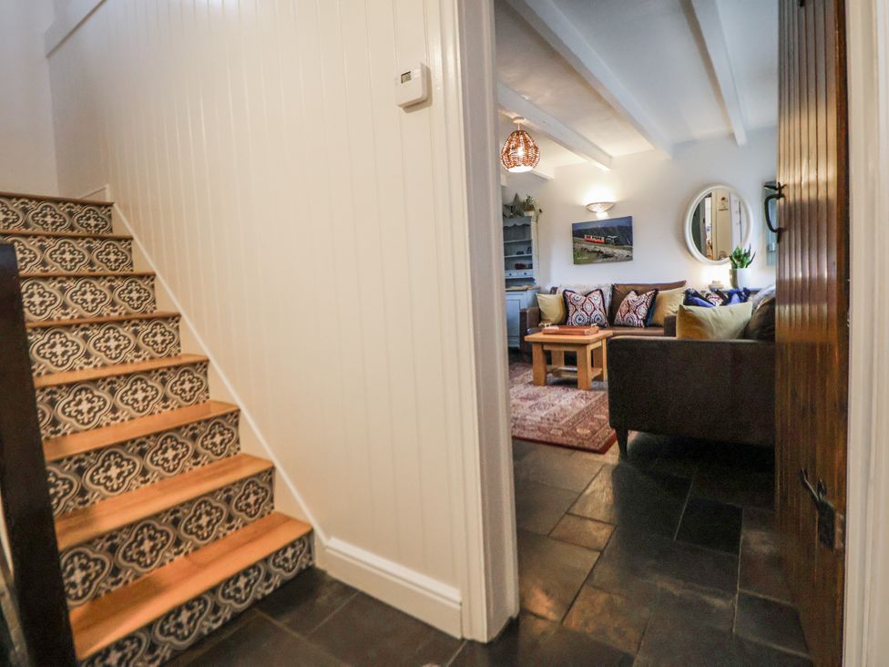 A hallway with stairs leading to a living room at The Coach House in Prestatyn