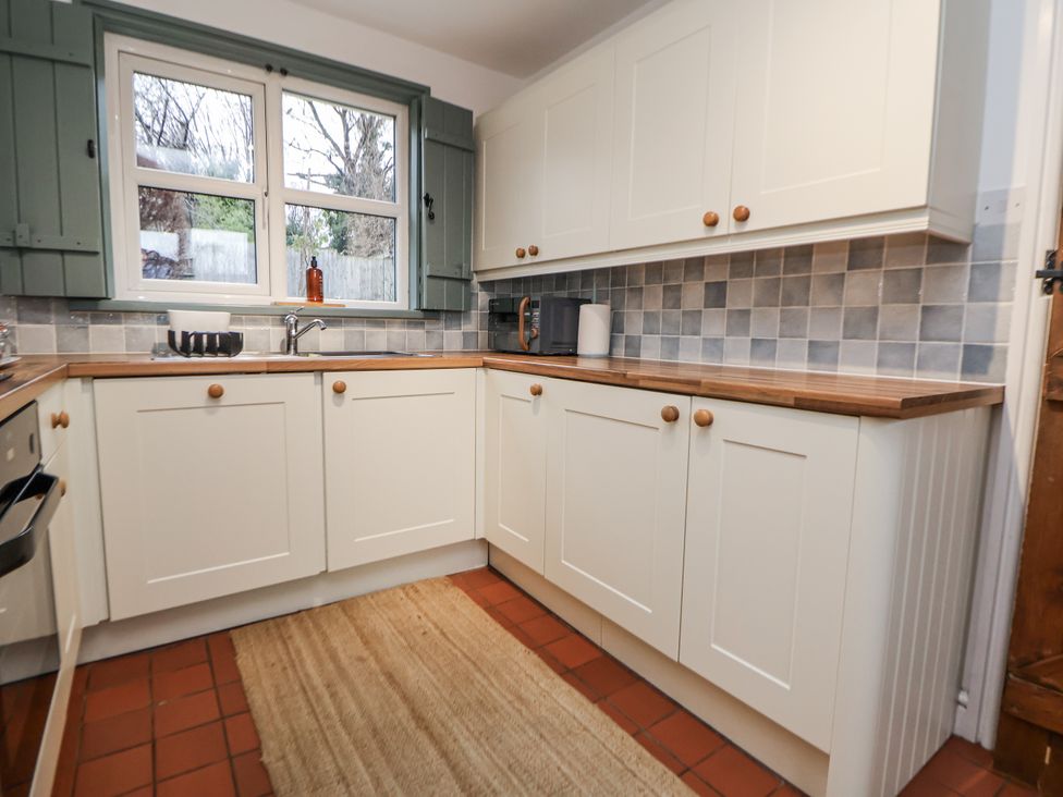 A kitchen with cabinets and a sink at The Coach House in Prestatyn