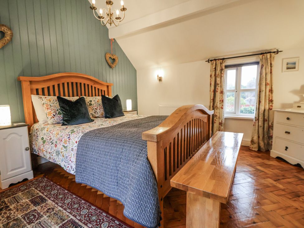 A bedroom with a bed and bench at The Coach House in Prestatyn
