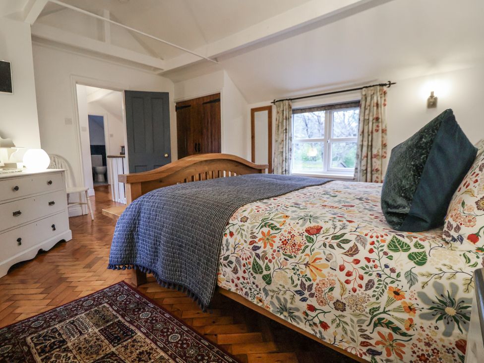 A bedroom with a bed and window at The Coach House in Prestatyn