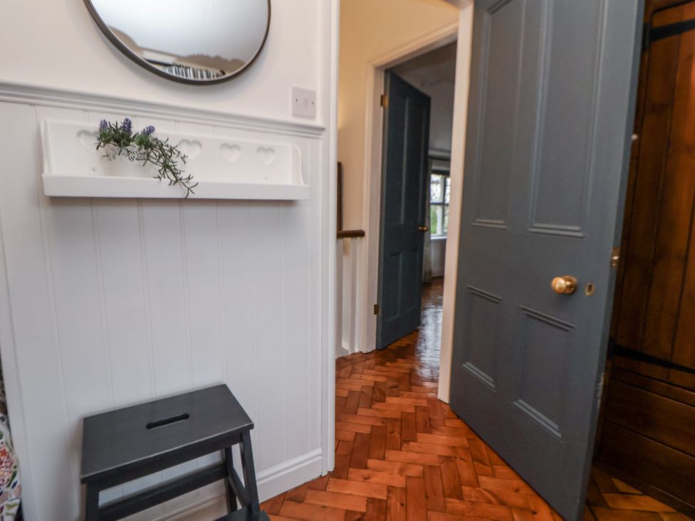 A hallway with a mirror and shelf at The Coach House in Prestatyn