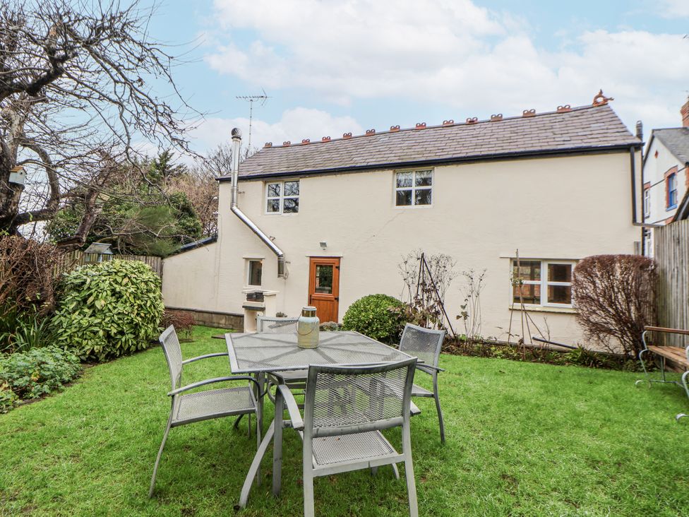 A garden with a table and chairs at The Coach House Prestatyn