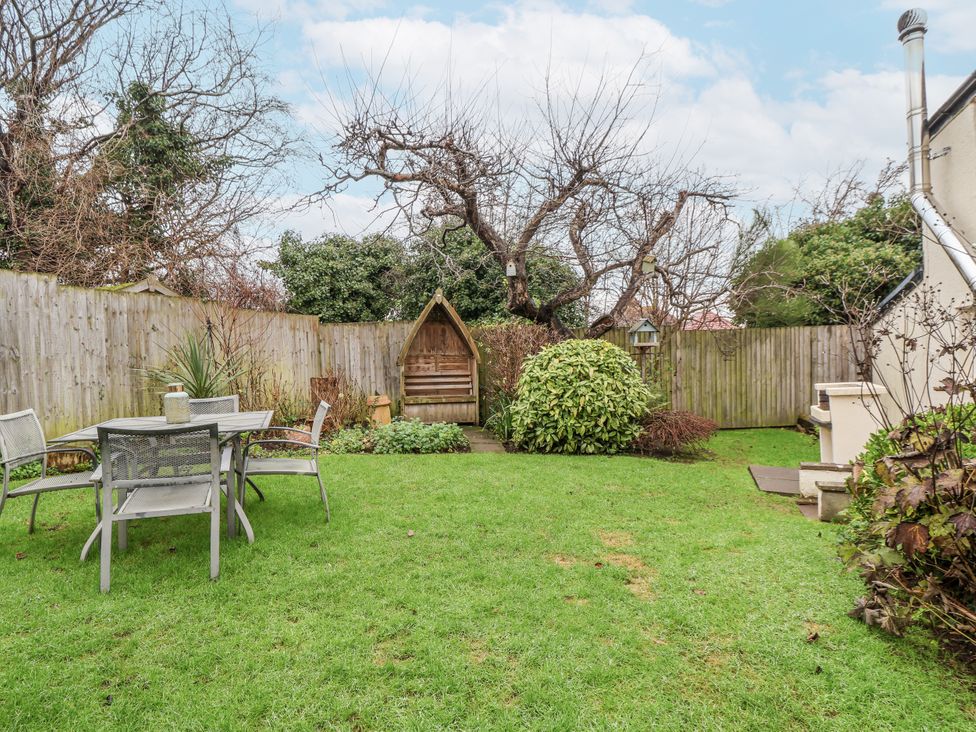 A garden with a table and chairs at The Coach House in Prestatyn
