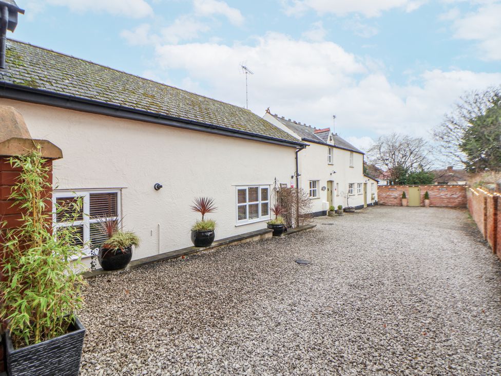An outdoor area with a building and gravel driveway at The Coach House in Prestatyn