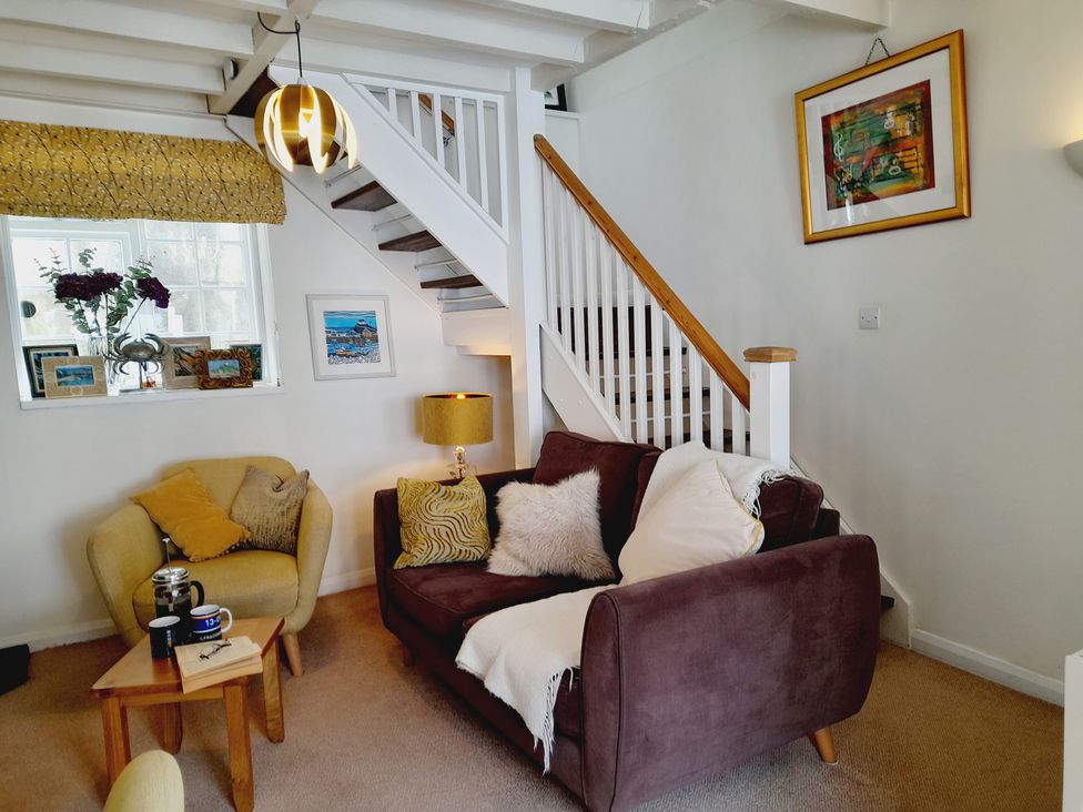 A living room with a stairway and furniture at Crab Cottage in Ilfracombe