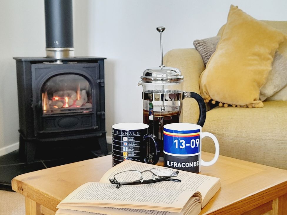 A living room with a coffee table and mugs at Crab Cottage Ilfracombe