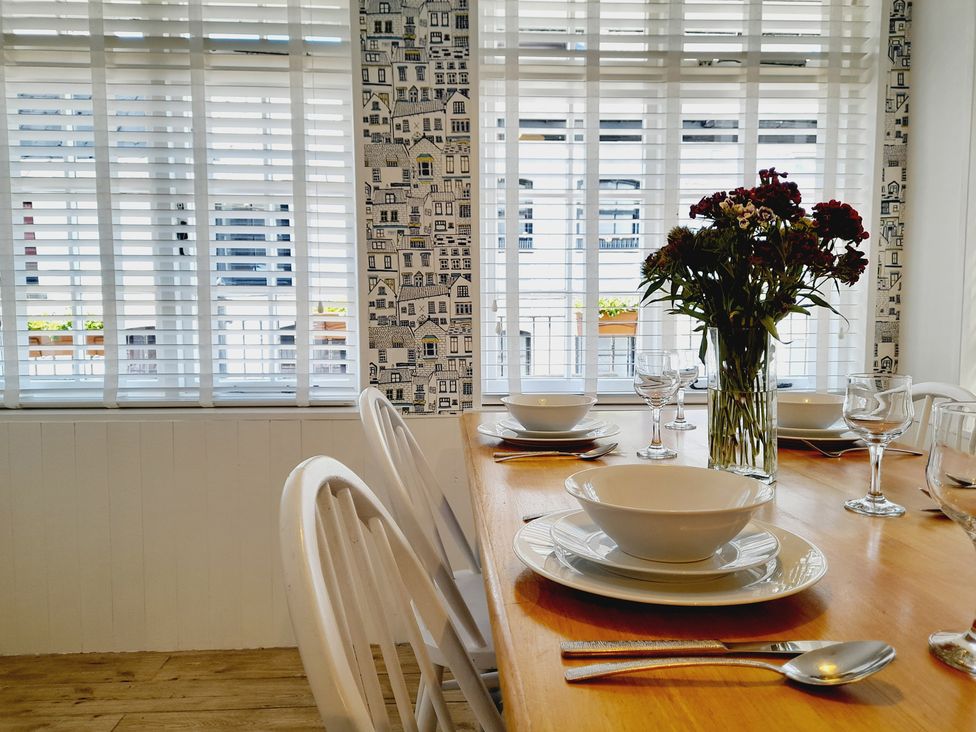 A dining room with a table set for a meal at Crab Cottage in Ilfracombe