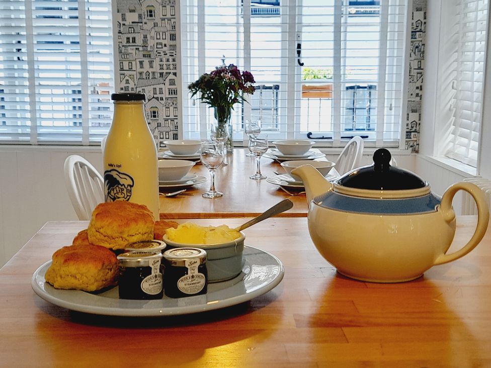 A kitchen with scones, milk, and tea pot at Crab Cottage in Ilfracombe