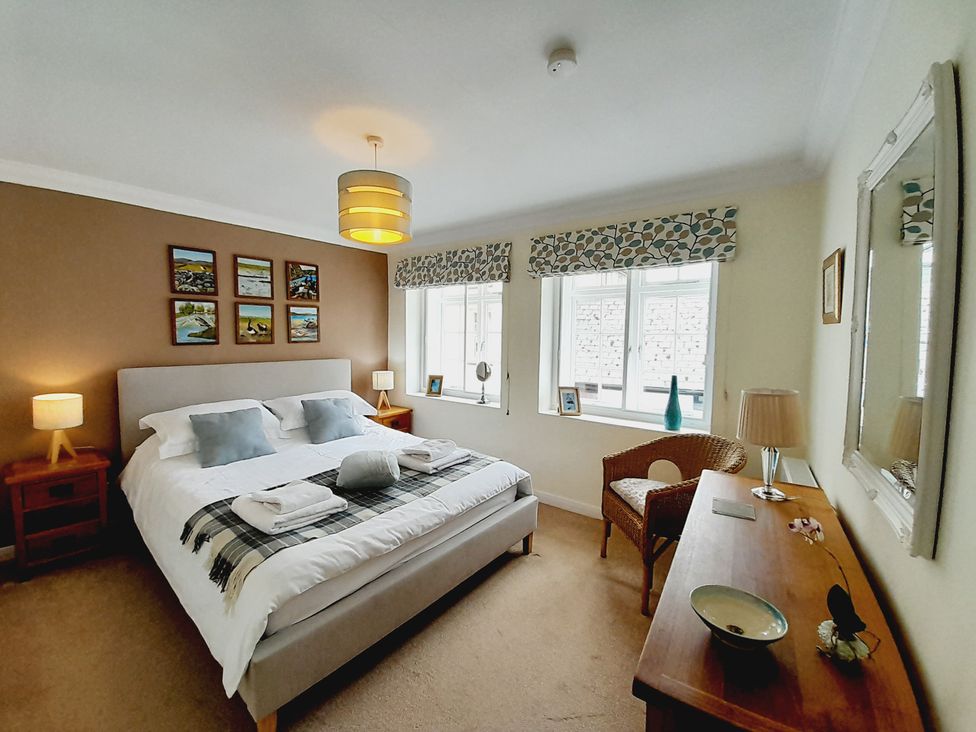 A bedroom with a bed and bedside table at Crab Cottage in Ilfracombe
