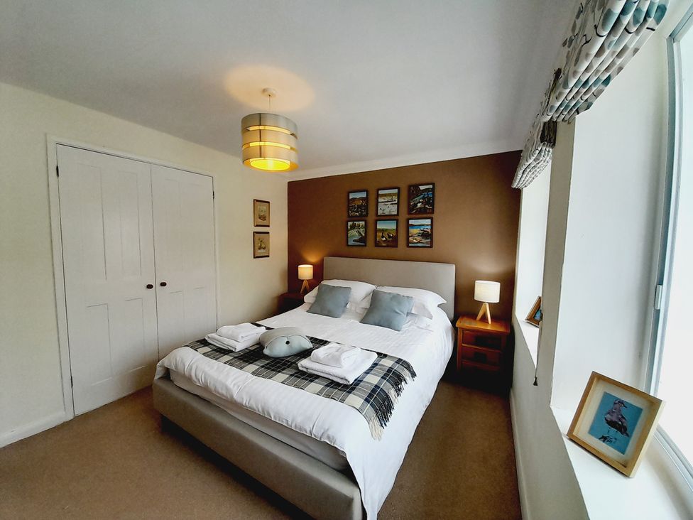 A bedroom with a bed and bedside table at Crab Cottage in Ilfracombe