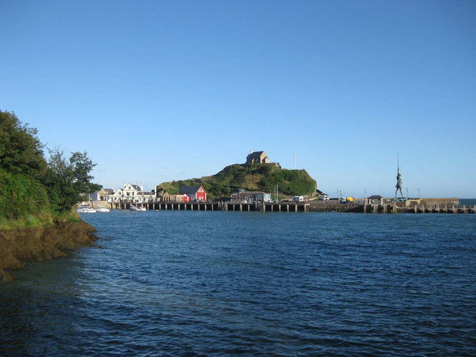 A view of a pier and buildings near the water at Crab Cottage in Ilfracombe