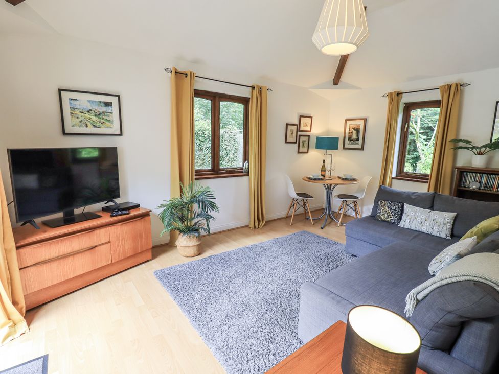 A living room with a television and a sofa at Doe Foot Cottage Ingleton