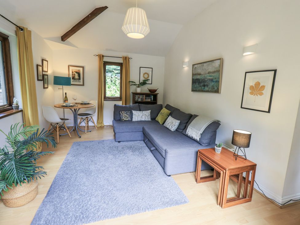 A living room with a sofa and dining area at Doe Foot Cottage Ingleton