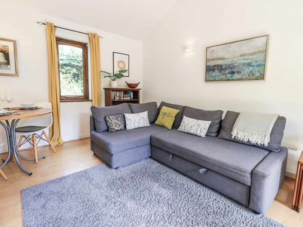 A living room with a sofa and dining table at Doe Foot Cottage in Ingleton