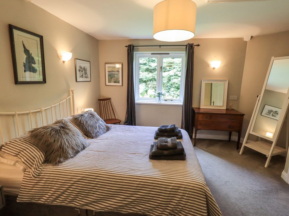 A bedroom with a bed and a table at Doe Foot Cottage Ingleton